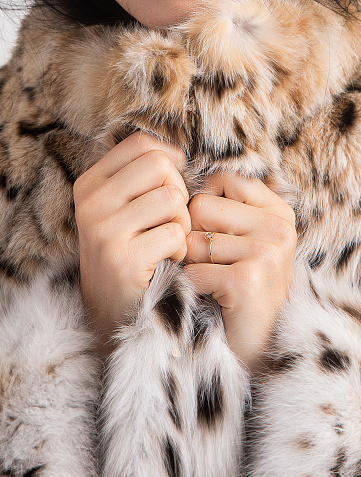 Woman holding her fur with her hands. Close-up. His face is not visible. The texture of the fur is visible. Unbranded fur.