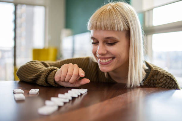 istock Woman pushing domino pieces 1470358311