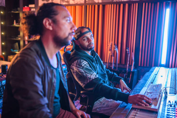 istock Two Male Musicians Operating With Sound Recording Studio Mixer 1470359329