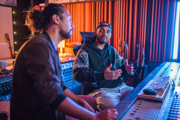 istock Two Male Musicians Operating With Sound Recording Studio Mixer 1470359346