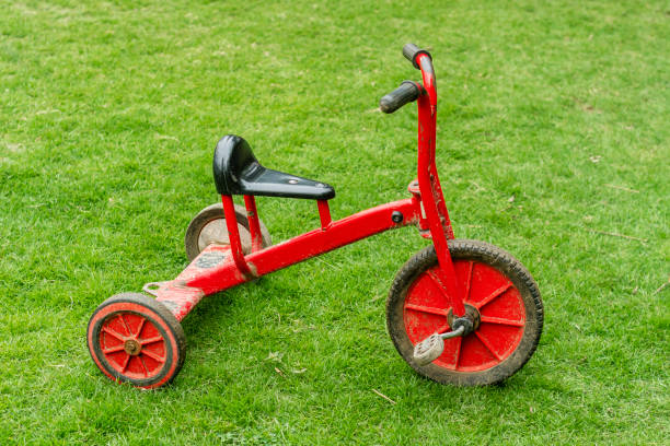 istock Red used tricycle on lush green grass. Close-up. 1470367461
