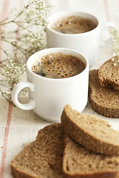 Served place setting: Two cups of black coffee and corny bread