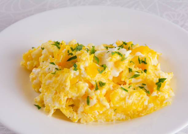 istock Scrambled eggs on plate, breakfast food, closeup, white background 1470376364