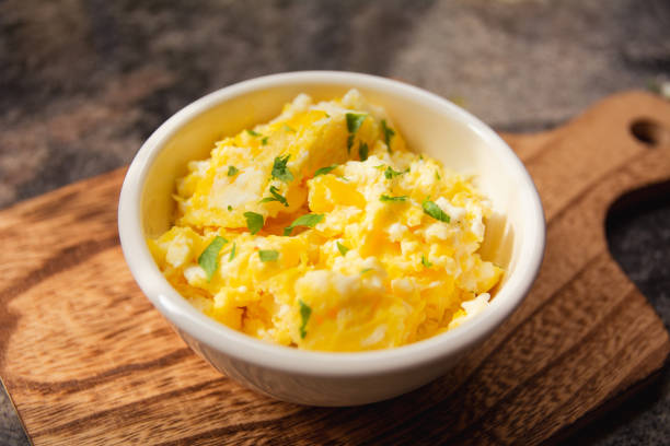 istock Scrambled eggs on bowl, wooden table, close up view 1470376374