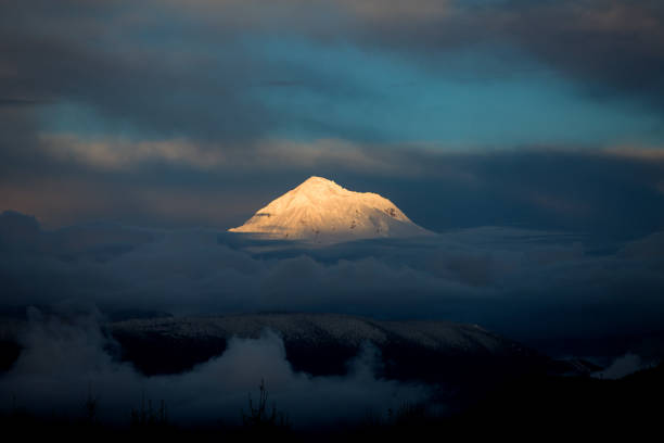 Mountain light surrounded by darkness stock photo