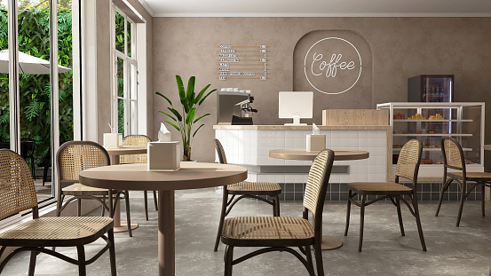 Modern, luxury tropical design cafe, counter, espresso machine, cake display fridge, rattan chair, coffee table in sunlight from outdoor garden on beige brown stucco wall, cement floor.