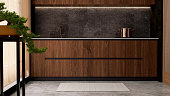 Luxury, modern beautiful wood grain wooden counter, black granite splashback, cupboard, gray tile floor in Asian style kitchen and bonsai tree in sunlight