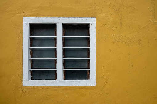Bright yellow exterior wall with white window