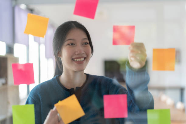 istock Young confident Businesswoman planning with adhesive notes in creative office. 1470385009