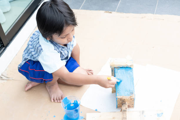 istock Asian kindergarten boy painting on a DIY craft project. 1470386082
