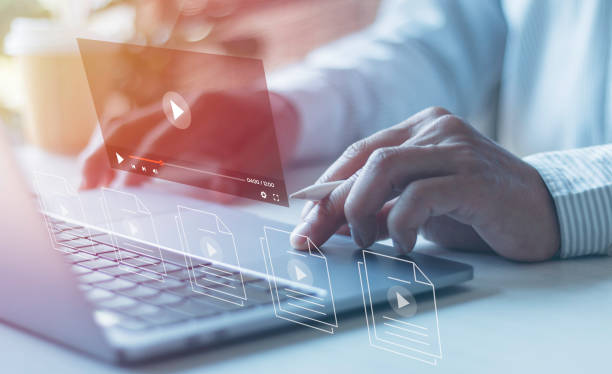 Businessman hands using laptops for streaming online on virtual screens, watching videos on the internet, live concert, show or tutorial, and content online.
