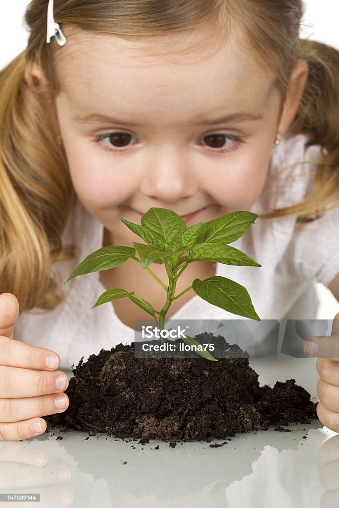 Niña feliz joven planta de observar - Foto de stock de Agricultura libre de derechos