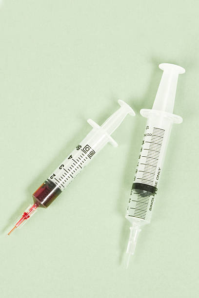 Two syringes on green background stock photo