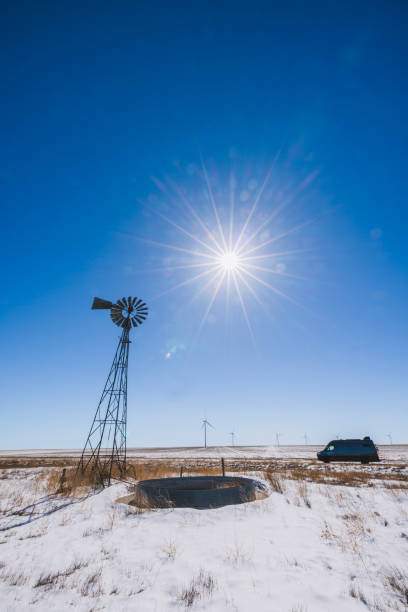 anciens et nouveaux moulins à vent avec une camionnette garée par une journée d’hiver ensoleillée, kansas - road kansas long farm photos et images de collection