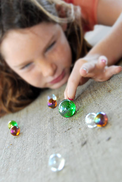 Young girl playing marbles