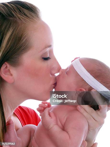 Joven Madre Sosteniendo A Su Bebé Niña Y Beso Foto de stock y más banco de imágenes de Adulto - Adulto, Adulto joven, Amor - Sentimiento