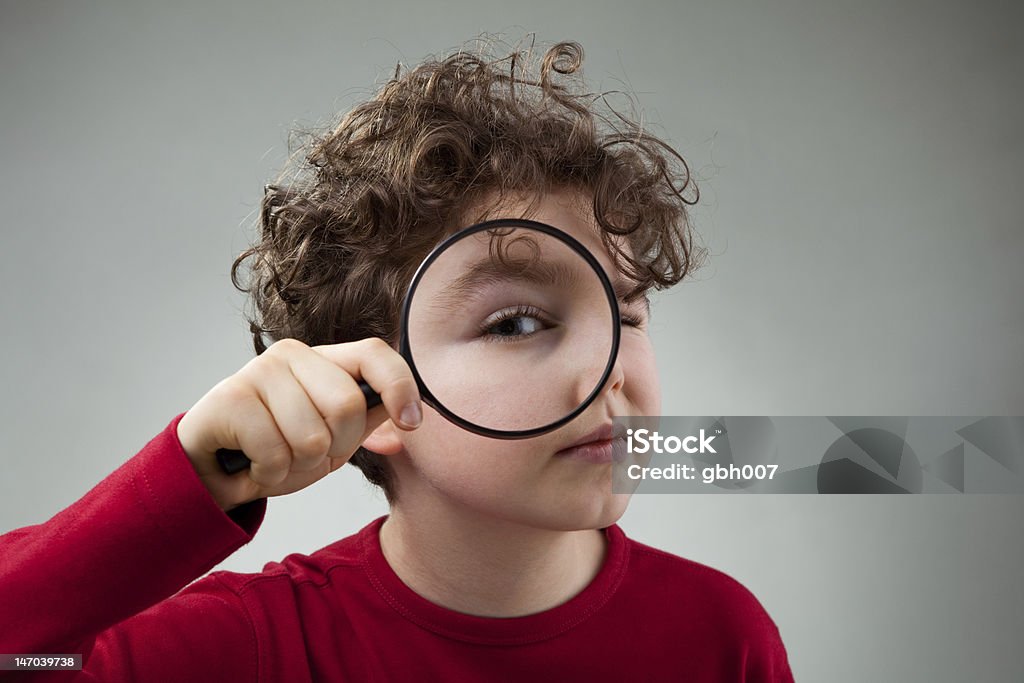 Boy and magnifying glass Boy using magnifying glass Magnifying Glass Stock Photo