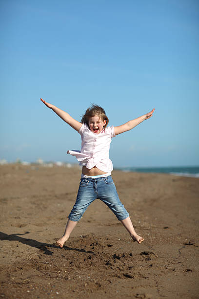 Happy girl is jumping on the beach stock photo
