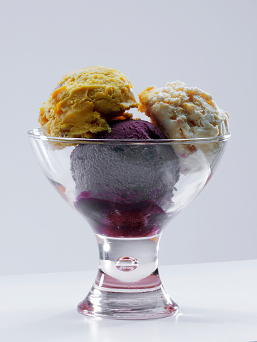 Raspberry ice cream scoop in bowl, close up view. Cold summer dessert