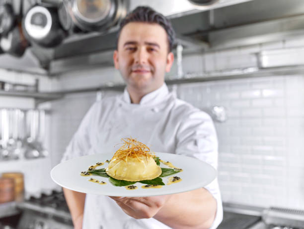 Master Chef Foie gras Chef serving Foie gras in a commercial kitchen smiling potato stock pictures, royalty-free photos & images