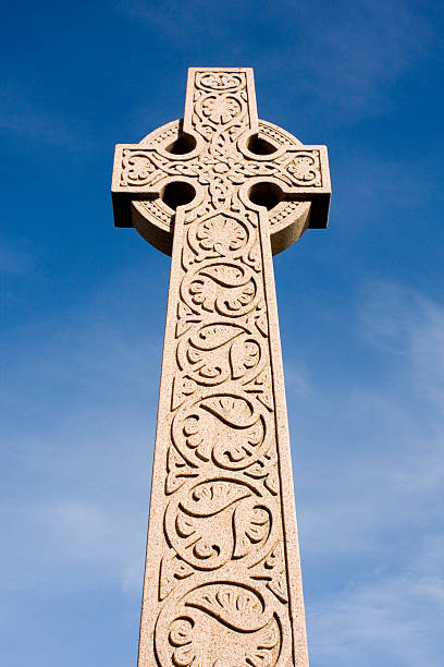 старинный кельтский крест против голубого неба. - celtic cross cross shape blue vertical стоковые фото и изображения