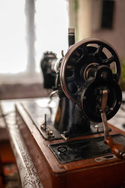istock Old sewing machine stands on the table at home ready to work and sew. 1470403609
