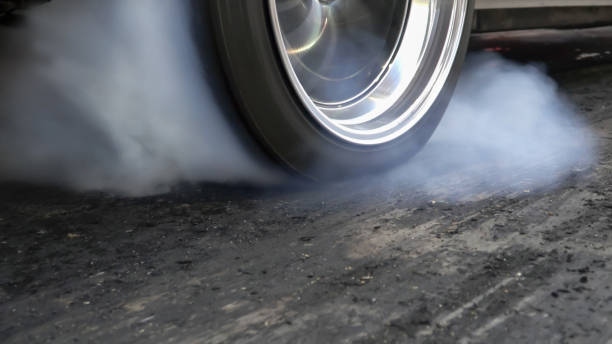 arrastre el neumático quemado del coche de carreras en la línea de salida en la pista de carreras - drag racing lighting equipment sports race auto racing fotografías e imágenes de stock