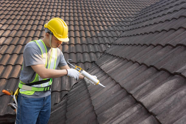 istock Worker man using silicone sealant adhesive  to fix crack of the old tile roof. 1470404584