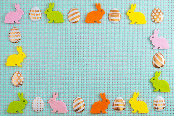 Colorfull eggs andl rabbits on blue background with copy space. Top view