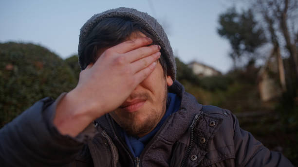 istock Young Man with Headache Sitting Outdoors in Nature 1470406684