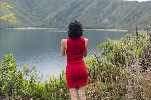 Breathtaking landscape- Woman gazing at the turquoise water lagoon surrounded by mountains