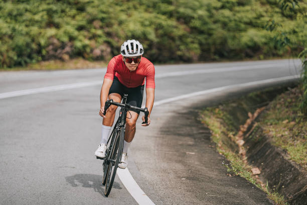 Asian Chinese professional cyclist athlete sportsman sprinting cycling in rural area stock photo
