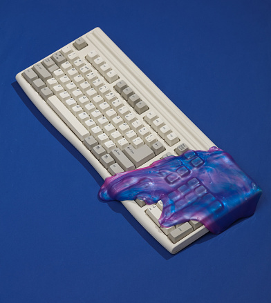 Creative retro layout, Old keyboard with space color slime on dark blue background with shadow. Visual trend. Fresh idea