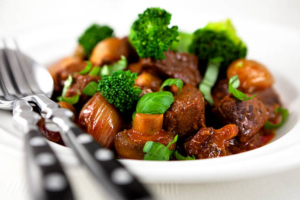 close up of braised beef with broccoli,mushrooms,onion and fresh basil