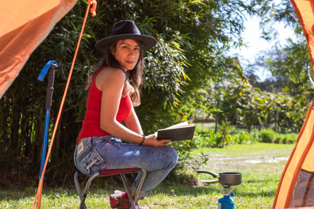 istock Reading in Nature: Woman Relaxing Outside Her Tent with a Book 1470413403