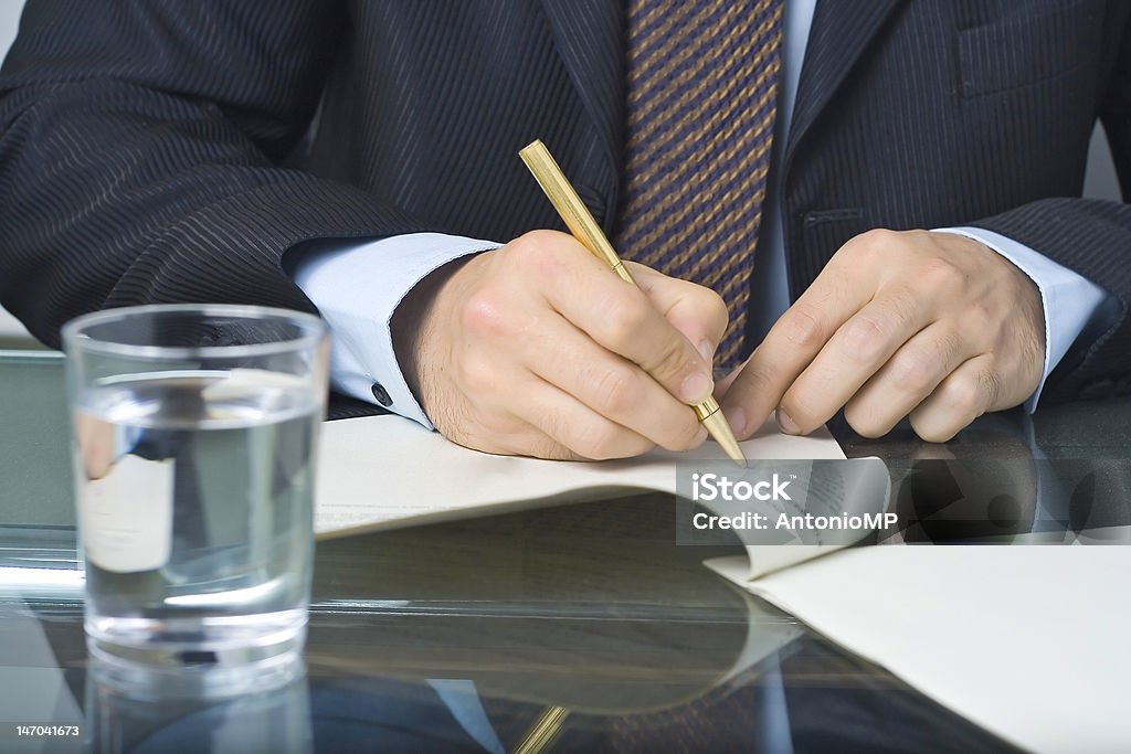 Uomo d'affari scrivendo in un documento - Foto stock royalty-free di Abbigliamento da lavoro