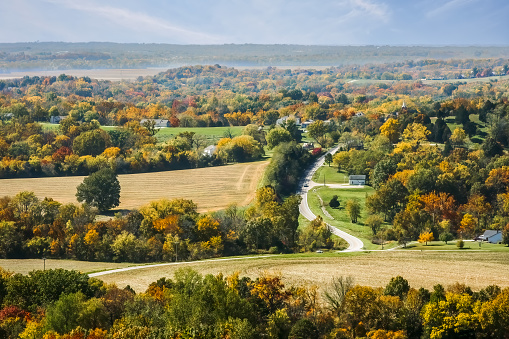 Rural Midwestern landscape with woods, fields, roads and houses in the fall