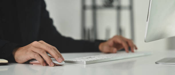 istock Cropped image of man typing on wireless keyboard, office worker working on white office desk. 1470417774