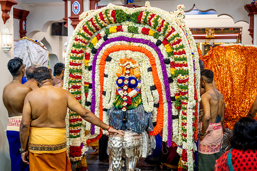 Singapore, Singapore -February 12, 2023 2023:People celebrating a Hindu festival inside Sri Mariamman Temple in Chinatown Singapore. This is the oldest Hindu temple of the city. It was founded in 1827. They carry the statue of goddess Durga around the temple