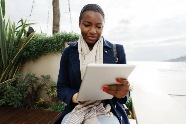 istock Black happy woman using a digital tablet outdoors 1470423860
