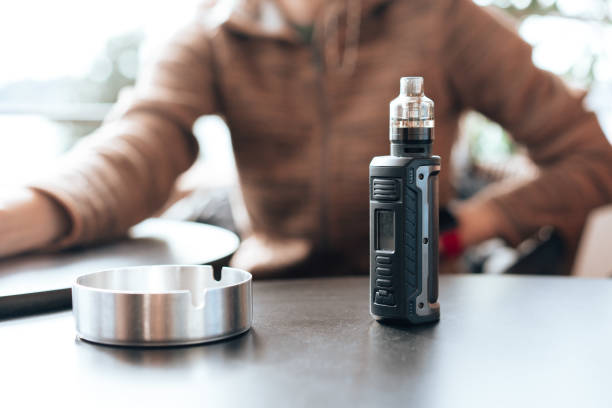 Vape stands on a wooden table in cafe stock photo