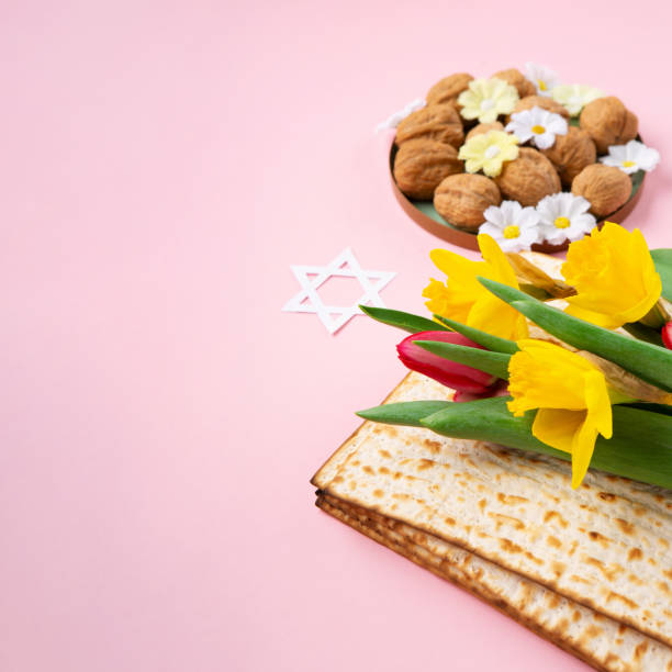 istock Passover Greeting Card with Matzah, Nuts and Spring Flowers on Pink Background. 1470427846