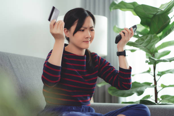 istock Asian woman holding credit card using smartphone have a problem with shopping and paying online. 1470427880