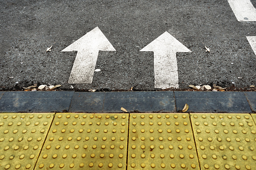 Two arrow signs as road markings on a street close up