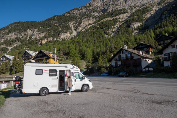 Young woman outside her camper van enjoying road trip She steps out to look at the beautiful surroundings, mountains. RV truck stock pictures, royalty-free photos & images