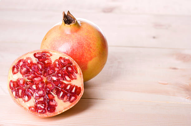 Pomegranate isolated on wood table stock photo