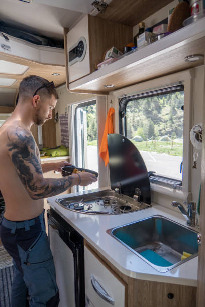 istock Young man in his camper van cooking 1470430322