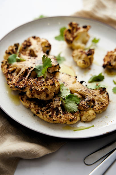 istock Baked cauliflower steak on white plate with cilantro leaves 1470430417