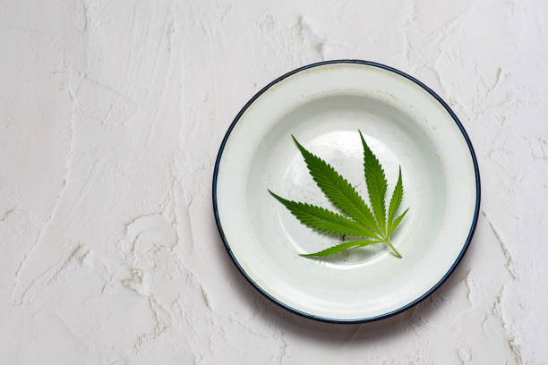 a cannabis leaf in a metal plate - photography sign table ganja imagens e fotografias de stock