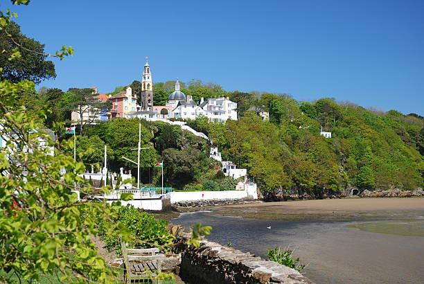 The Village of Portmeirion, Gwynedd, Wales Landscape view of the beautiful village of Portmeirion, Gwynedd, Wales showing the bay, woods, 'concrete boat' under a stunning blue summer sky. portmeirion stock pictures, royalty-free photos & images